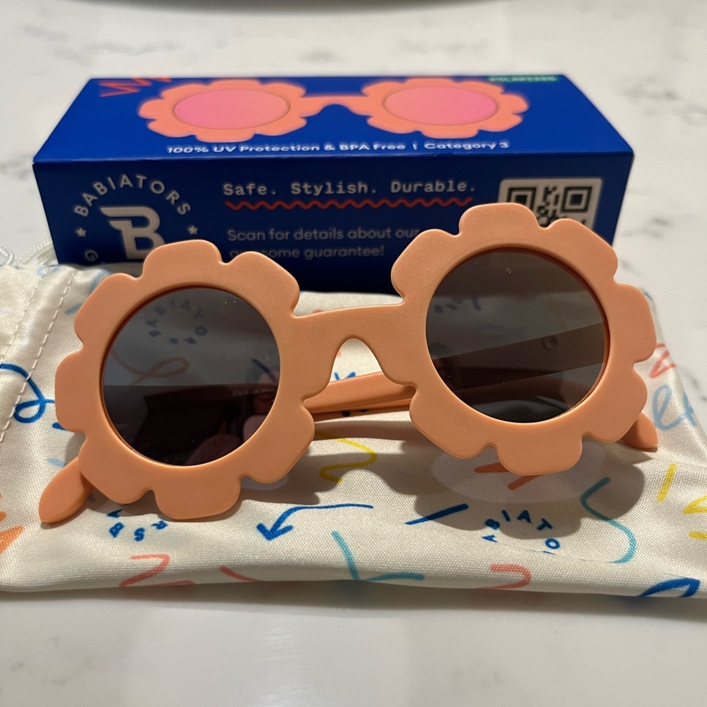 Babiators Peachy Keen flower shaped, pink peach-colored sunglasses.